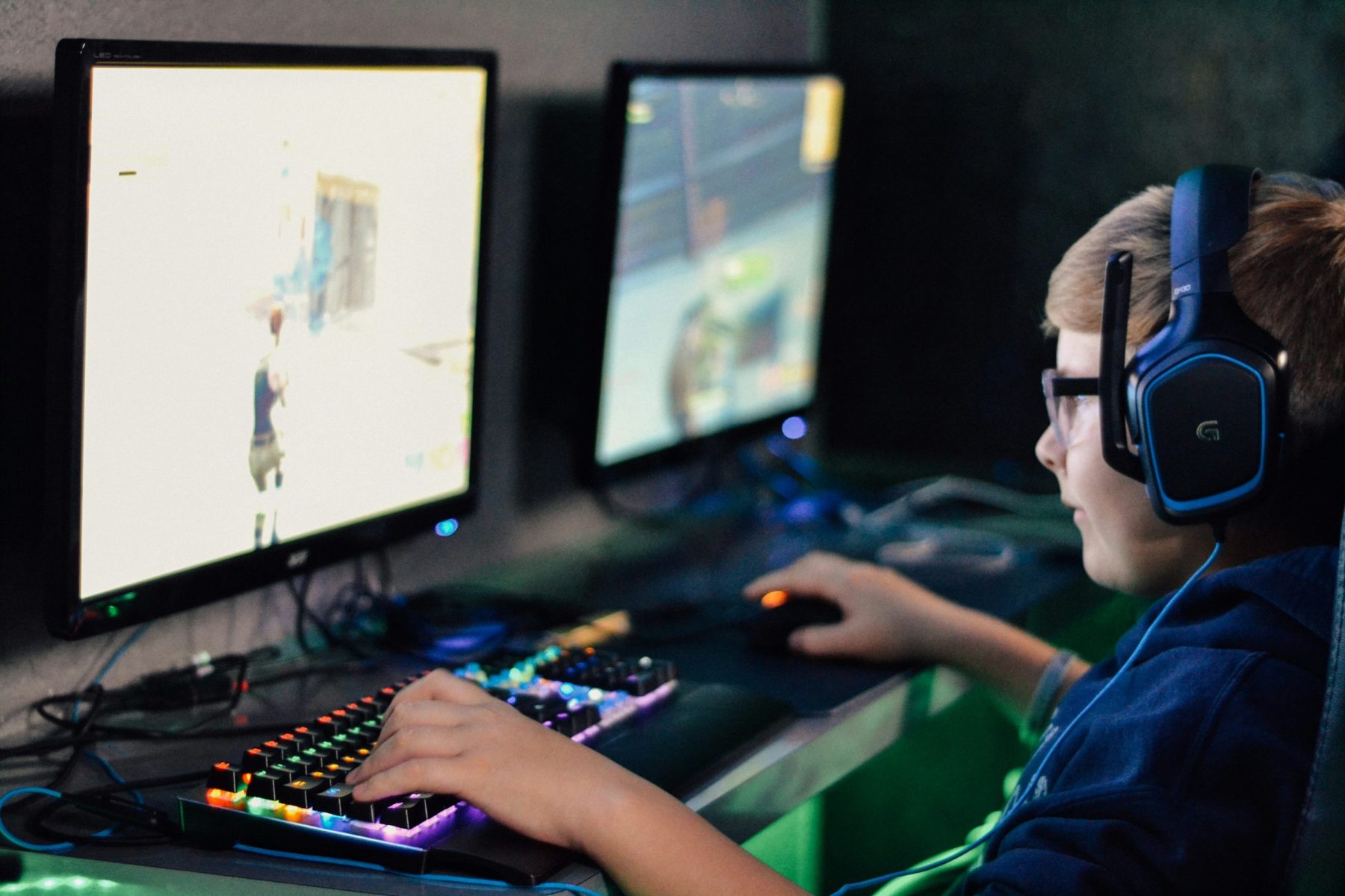 O Crescimento dos E-Sports: De Hobby Niche a Entretenimento Mainstream Menino usando fones de ouvido jogando jogo de computador.